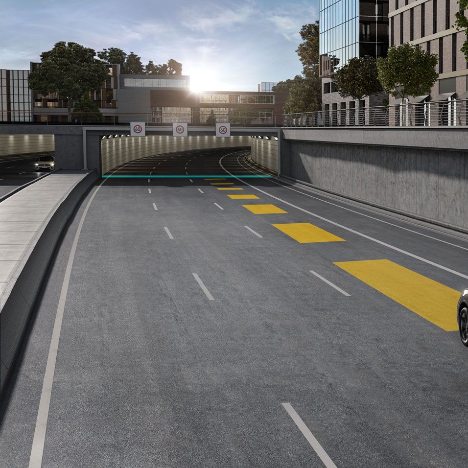 Ein grauer VW Touareg fährt auf einer leeren Straße auf einen Tunnel zu.