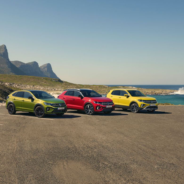 Taigo, T-Roc, T-Cross stehen geparkt auf einem Parkgelände, im Hintergrund sieht man das Meer.
