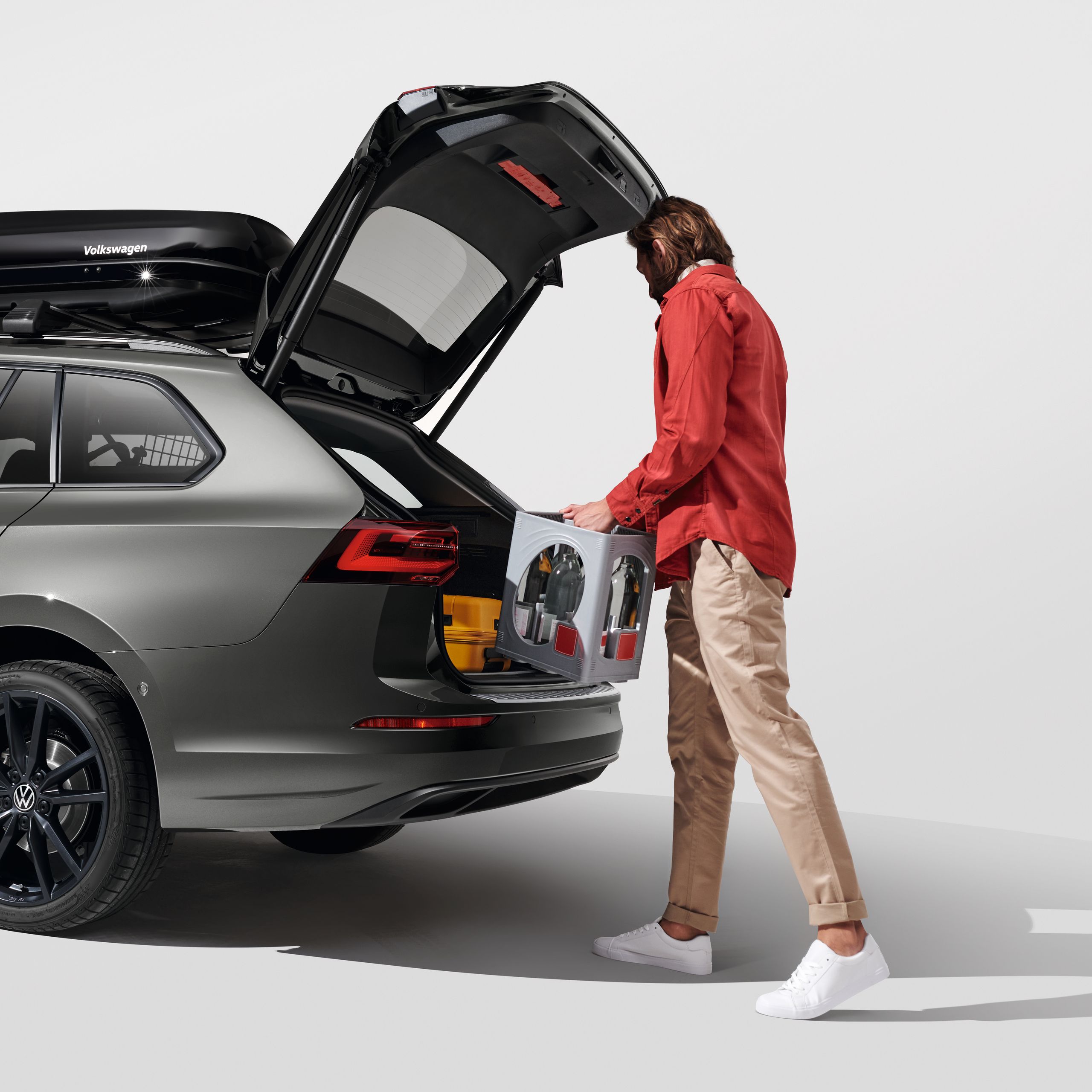 Ein Mann belädt den Kofferraum eines Volkswagen Golf Variant