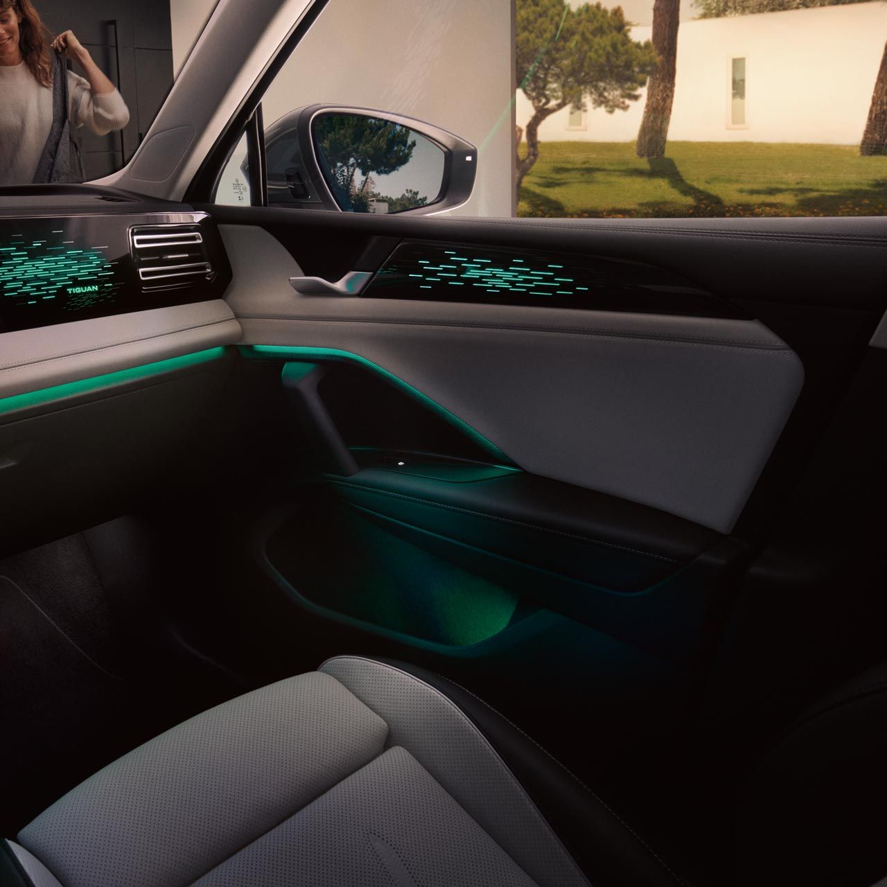 Innenansicht VW Tiguan nachts, Farbdisplay zeigt Einstellungen des optionalen Ambientelichts, Innenraum grün beleuchtet.