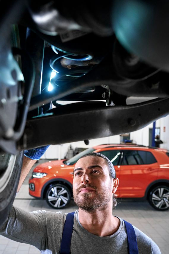 Ein VW Techniker überprüft einen Volkswagen Stoßdämpfer