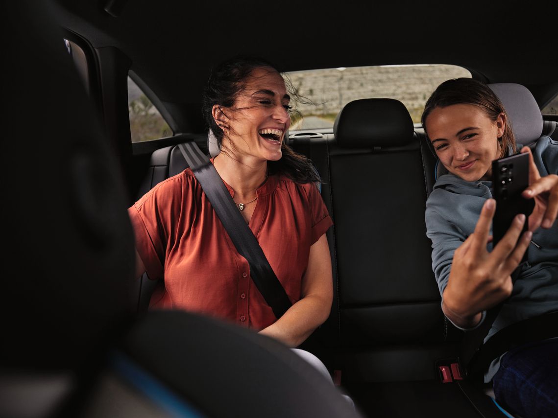 Zwei Frauen haben Spass auf dem Rücksitz eines Volkswagen
