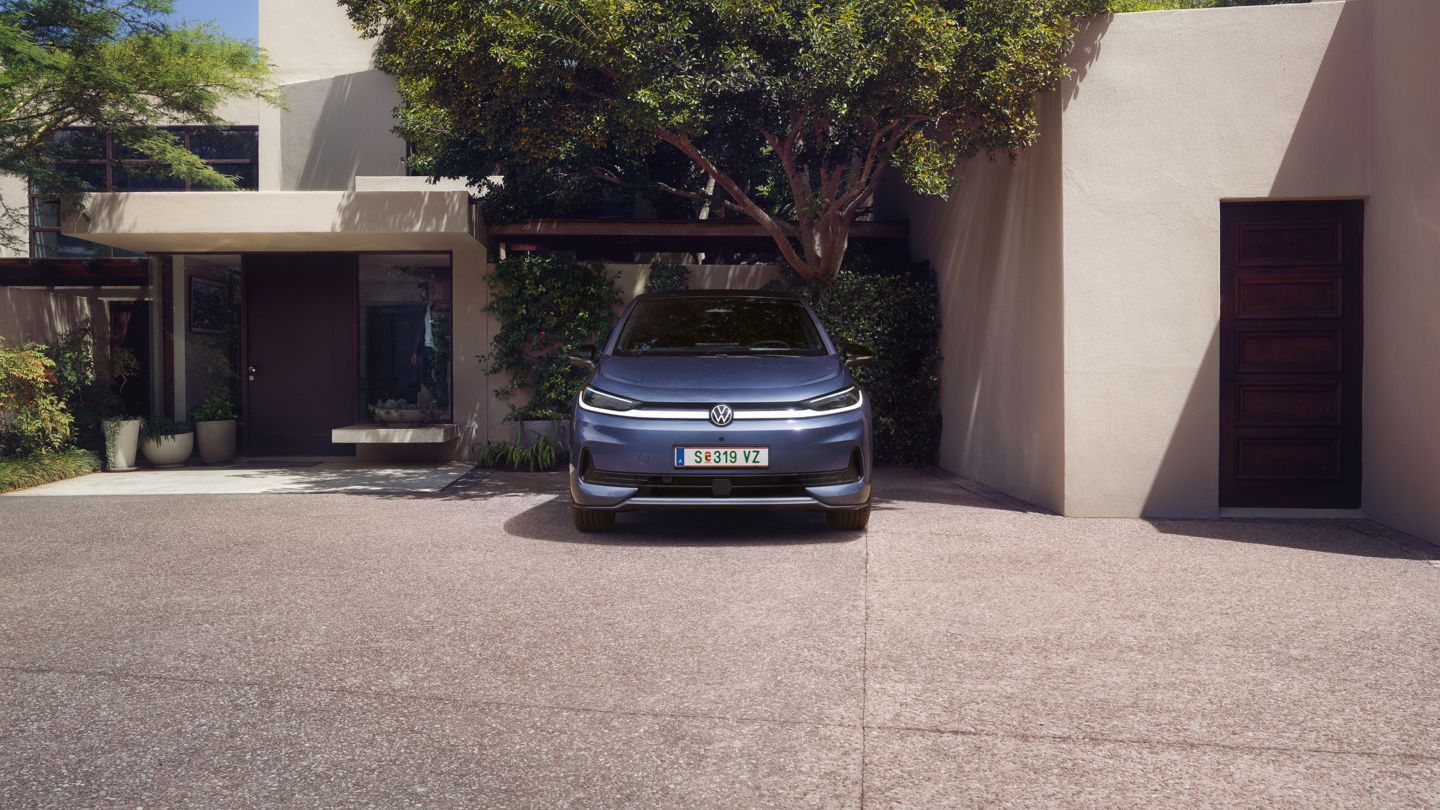 Ein blauer VW ID.3 Neo parkt vor einem Einfamilienhaus