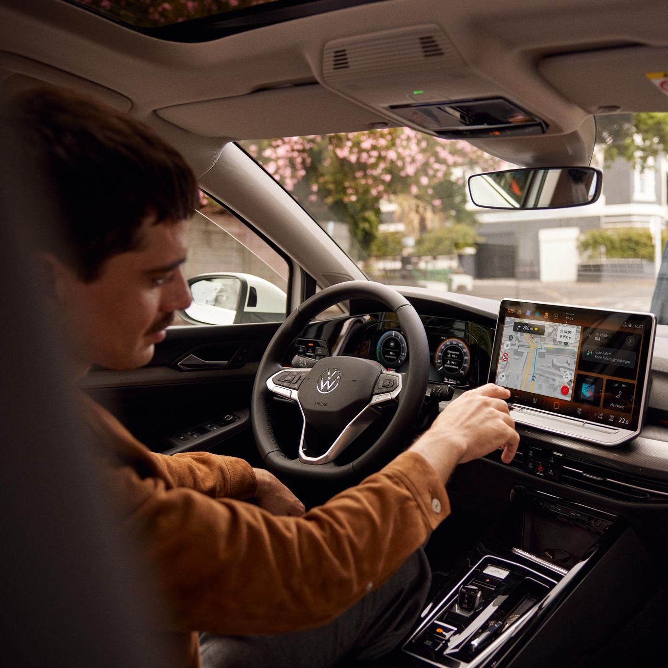Man bedient Touchscreen des Infotainmentsystems im VW Golf
