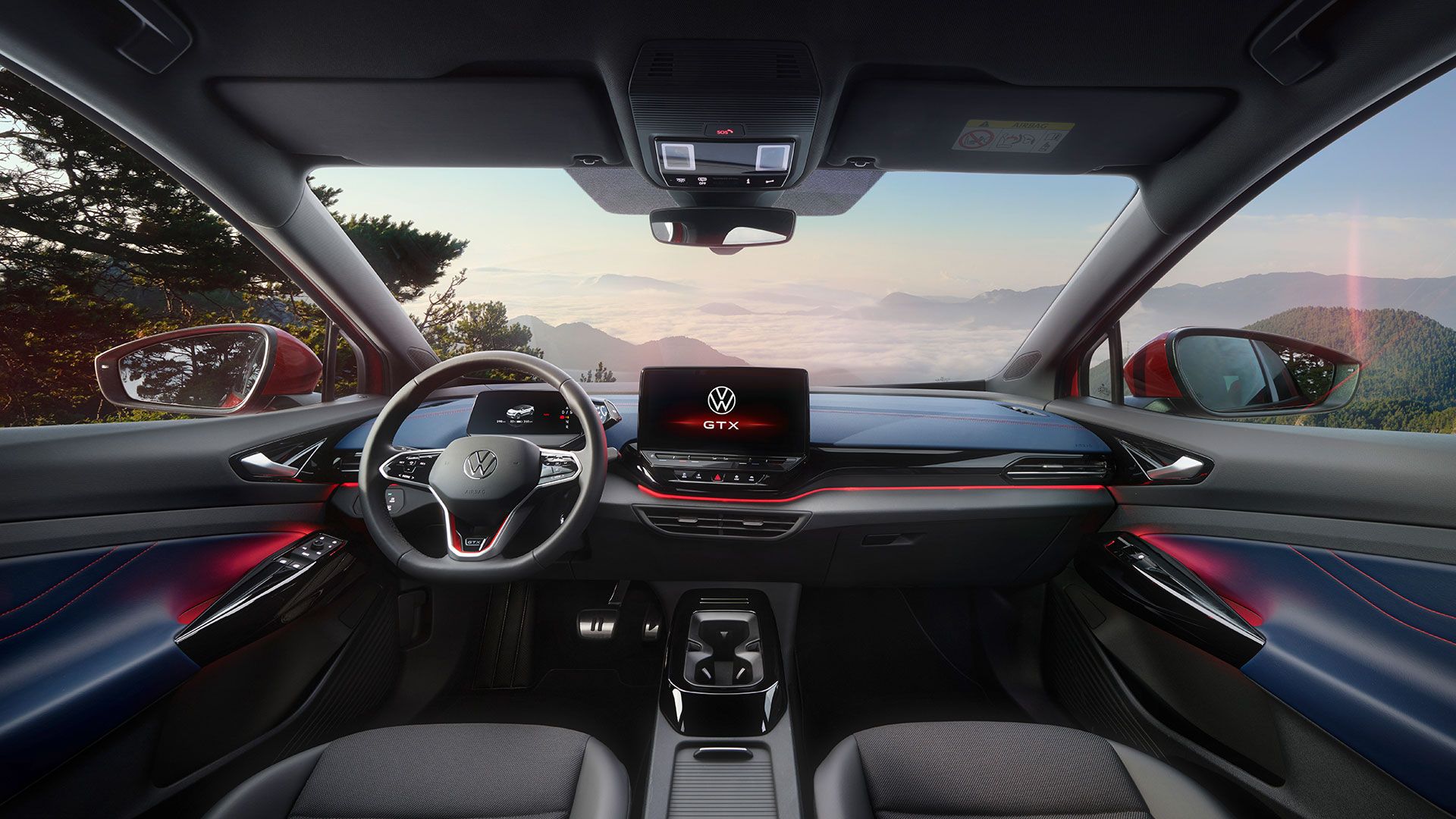 Innenraum von einem roten VW ID.5 GTX. Blick auf Lenkrad, Display, Sitze, Armaturen und Rückspiegel.