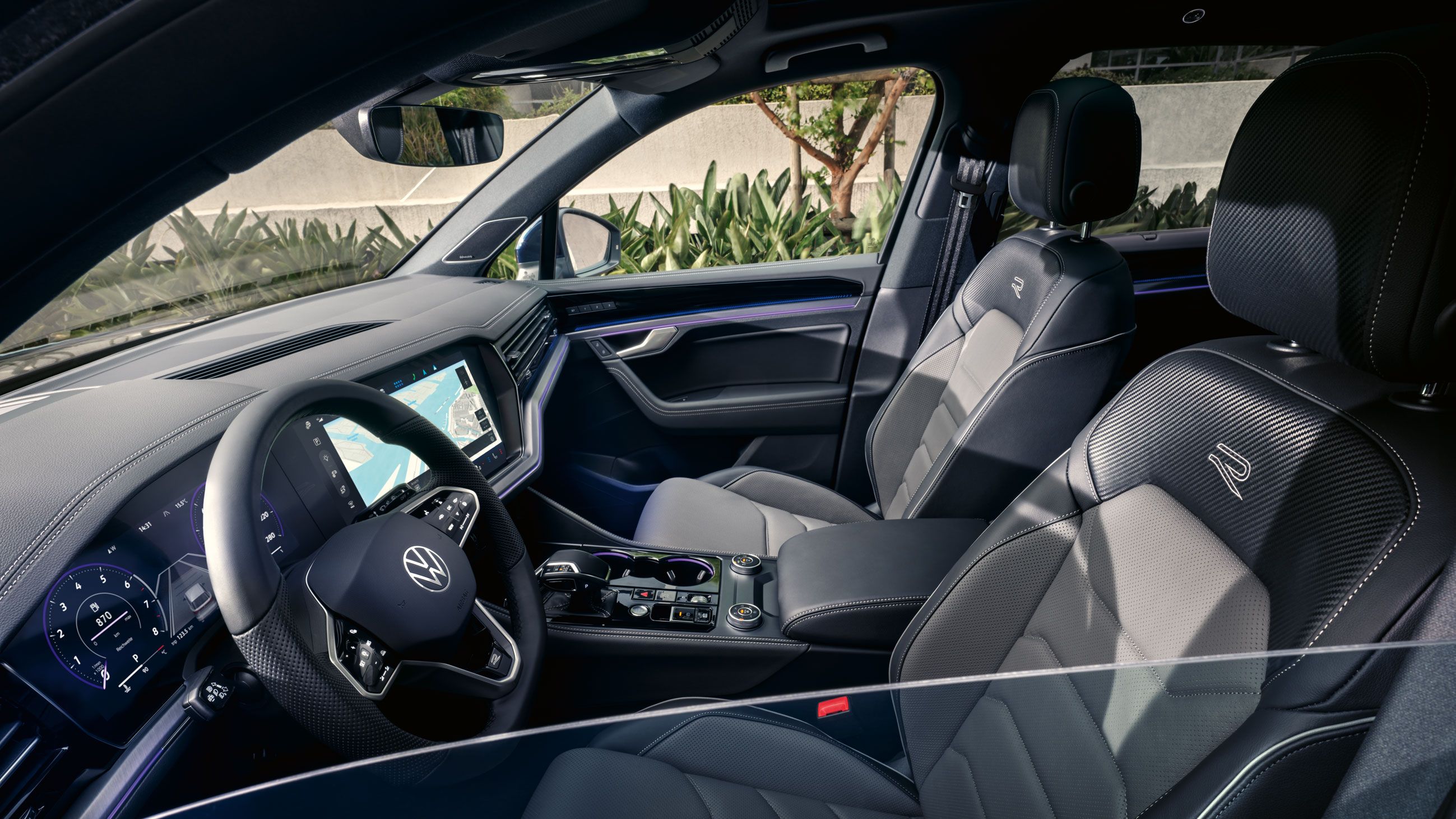 Blick durch das Seitenfenster auf das Interieur und die Vordersitze des VW Touareg R-Line.