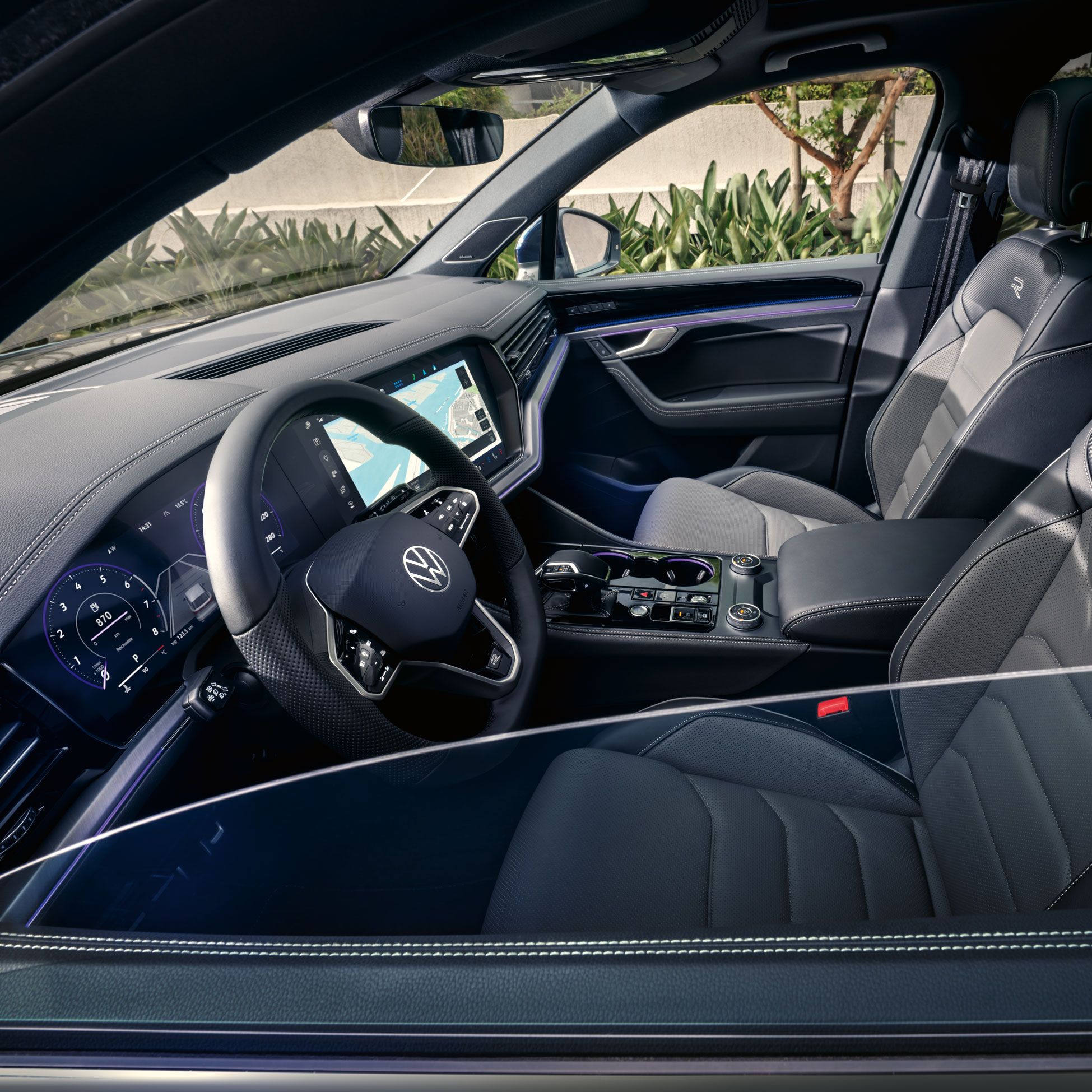 Blick durch das Seitenfenster auf das Interieur und die Vordersitze des VW Touareg R-Line.