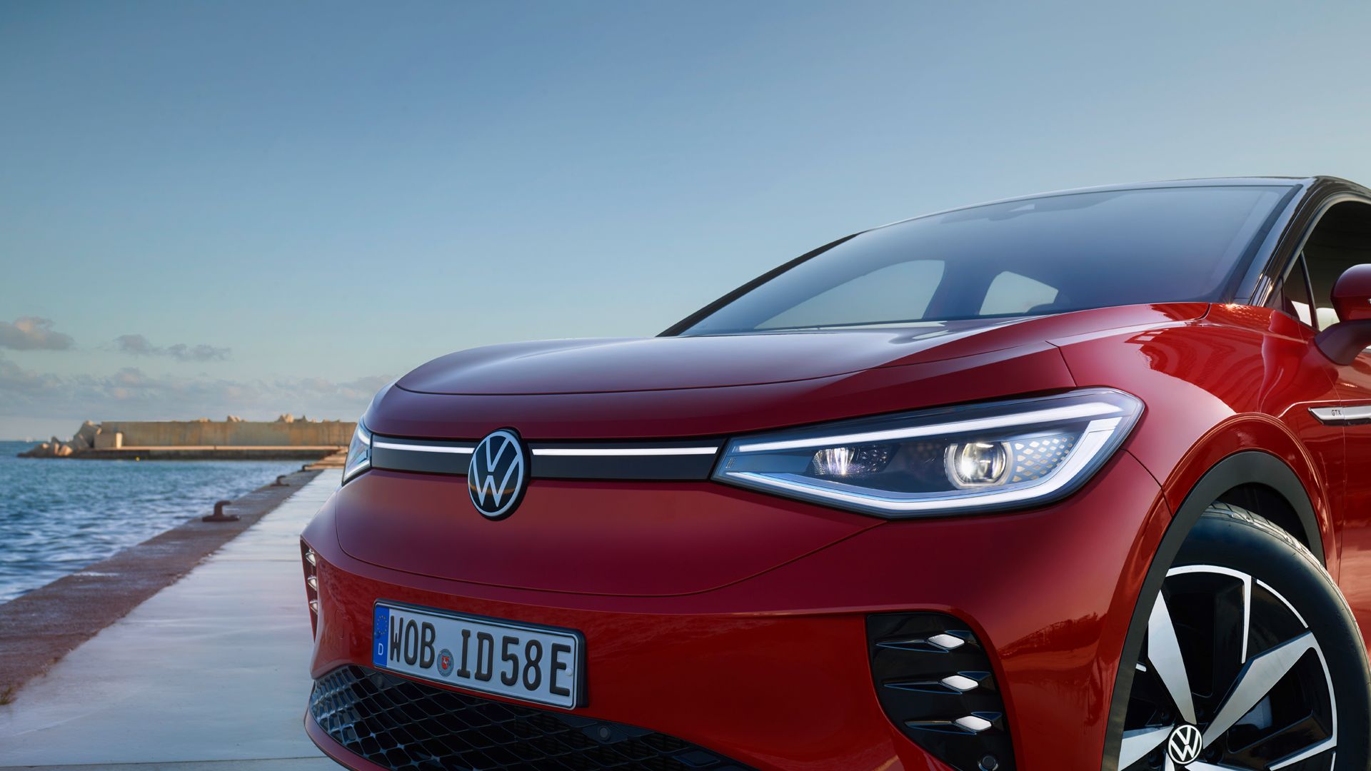 Roter VW ID.5 GTX an einem Hafen. Blick auf Front, LED-Matrix-Scheinwerfer und Räder.