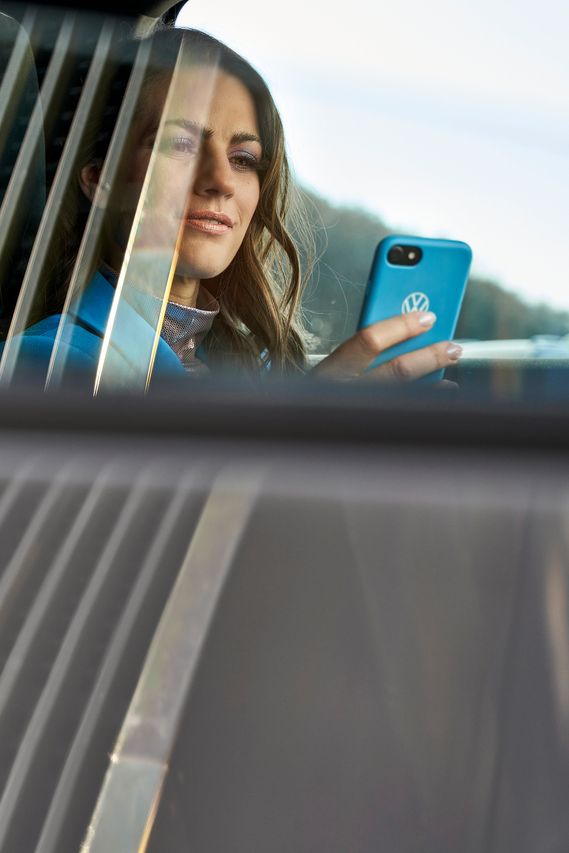 Frau schaut auf ein Handy im Auto
