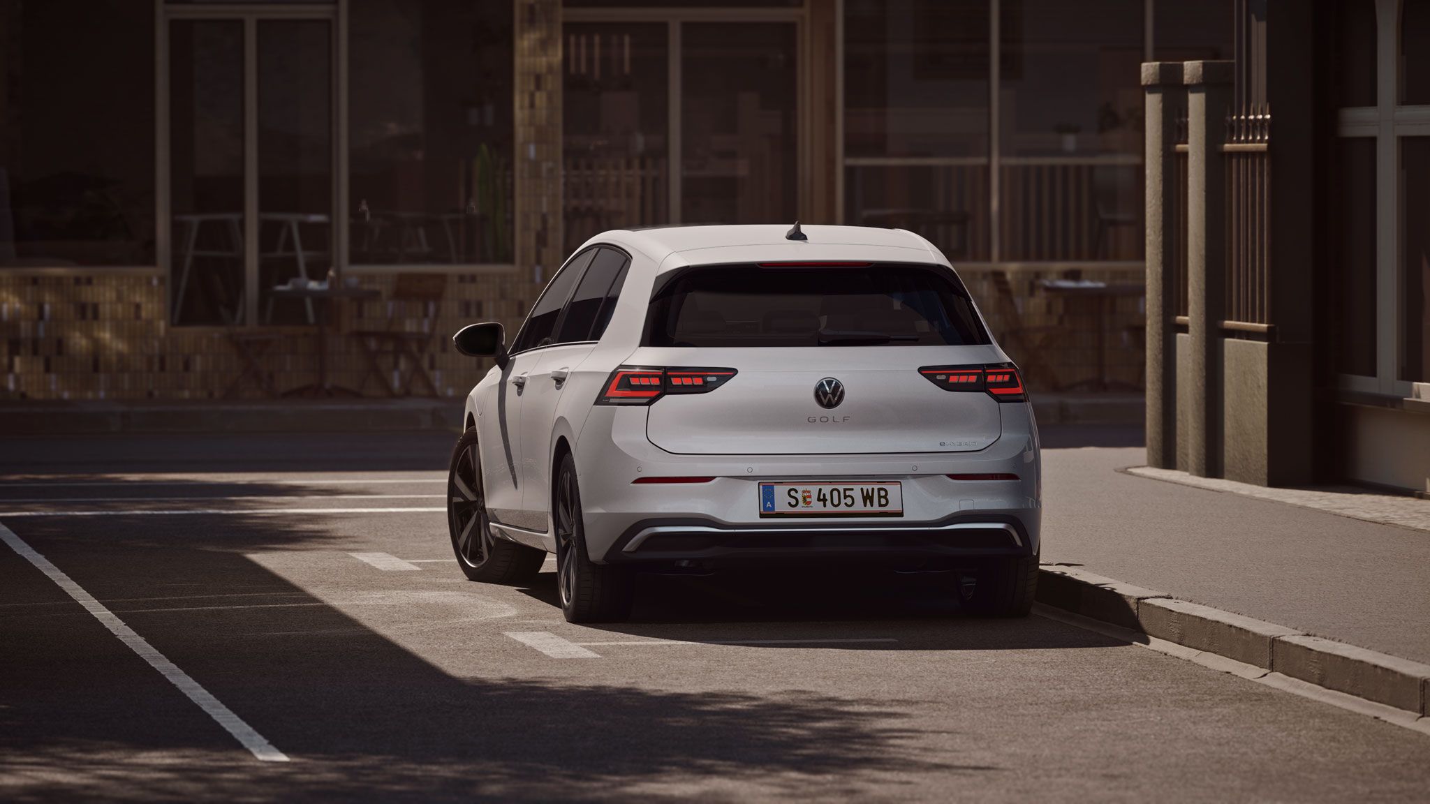 Heckansicht eines weißen VW Golf eHybrid der in einer Stadt geparkt ist