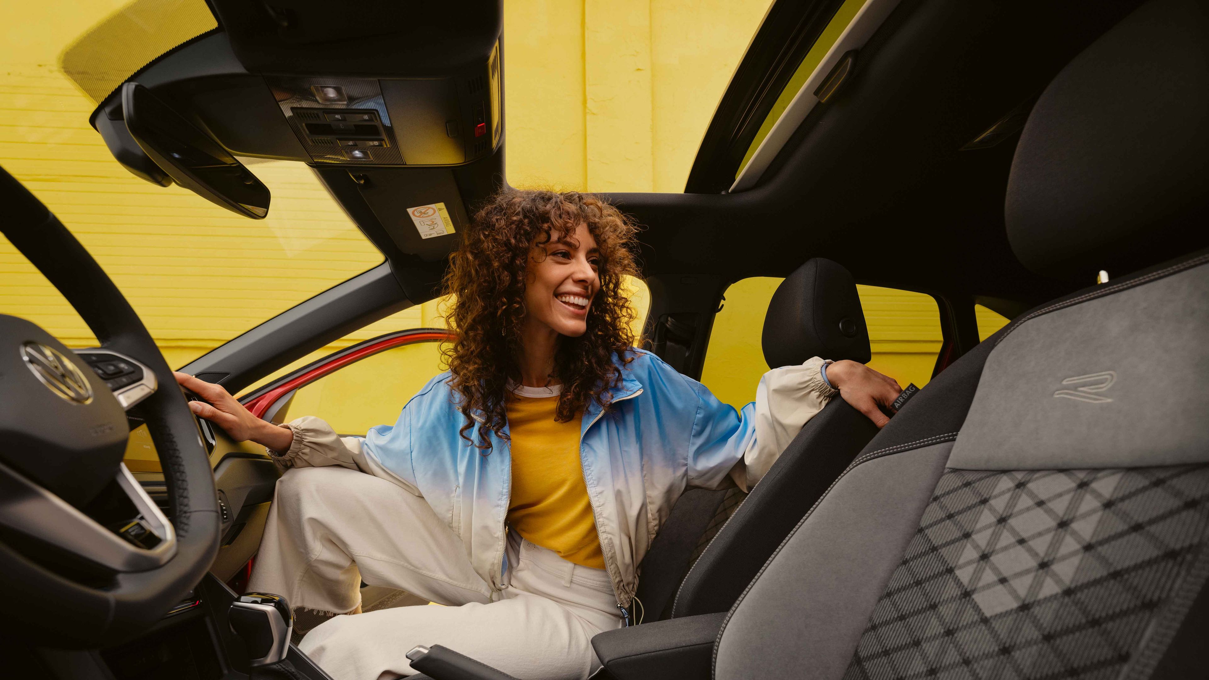 VW Taigo R-Line Interieur: Frau sitzt auf Beifahrersitz und schaut nach hinten