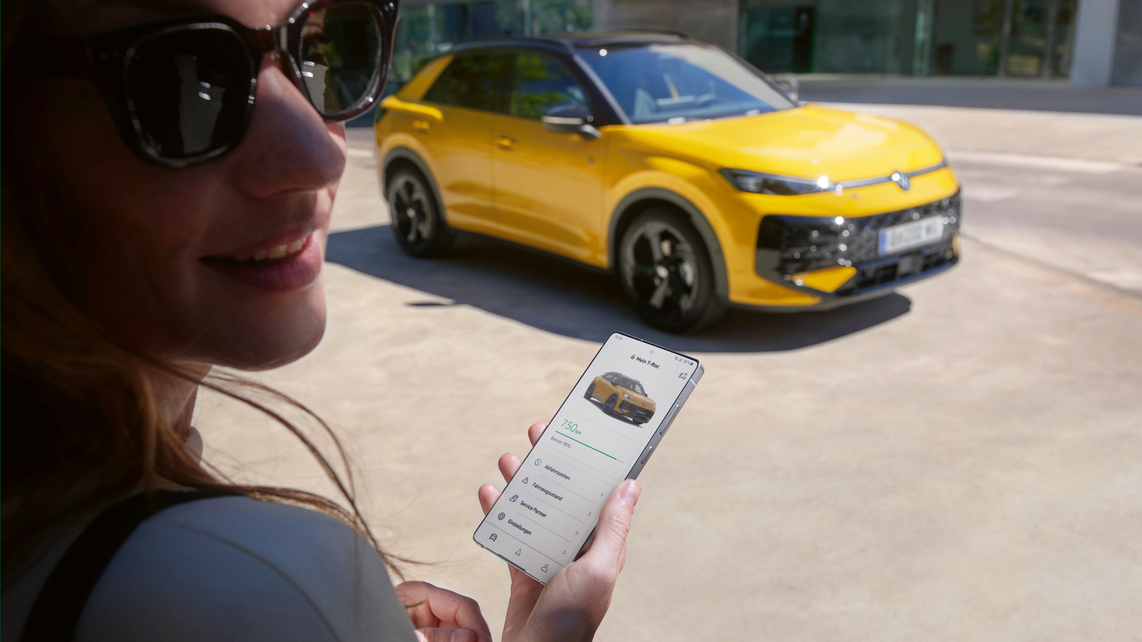 Eine Frau nutzt die App VW Connect nahe ihres VW T-Roc R-Line.