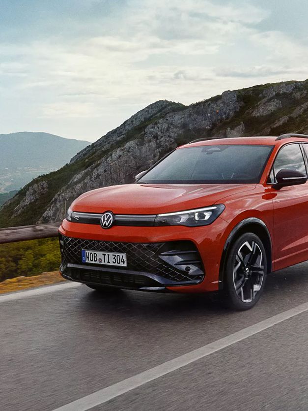 Roter VW Tiguan fährt eine Straße entlang.