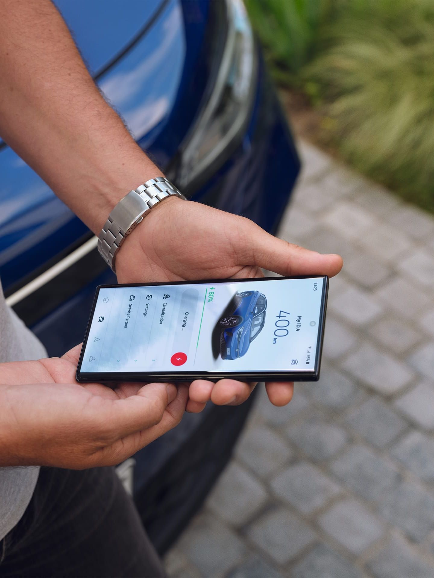 Detailansicht eines Mannes, der ein Smartphone in beiden Händen hält. Auf dem Display zu sehen die We Connect ID. App